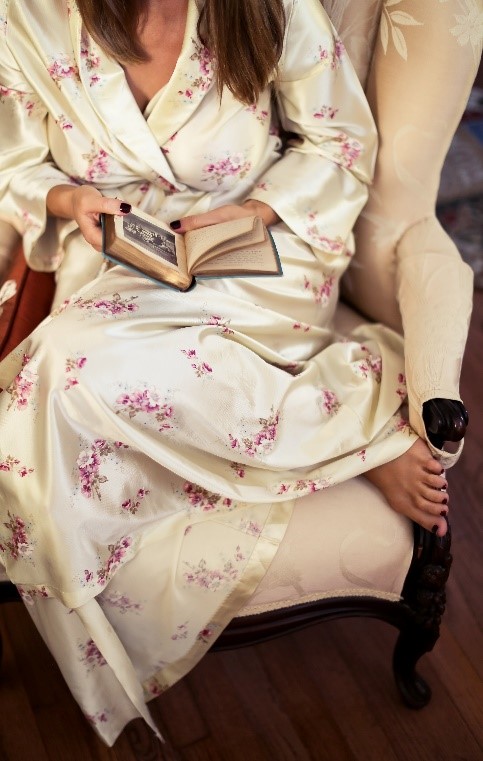 Woman in chair reading with robe on